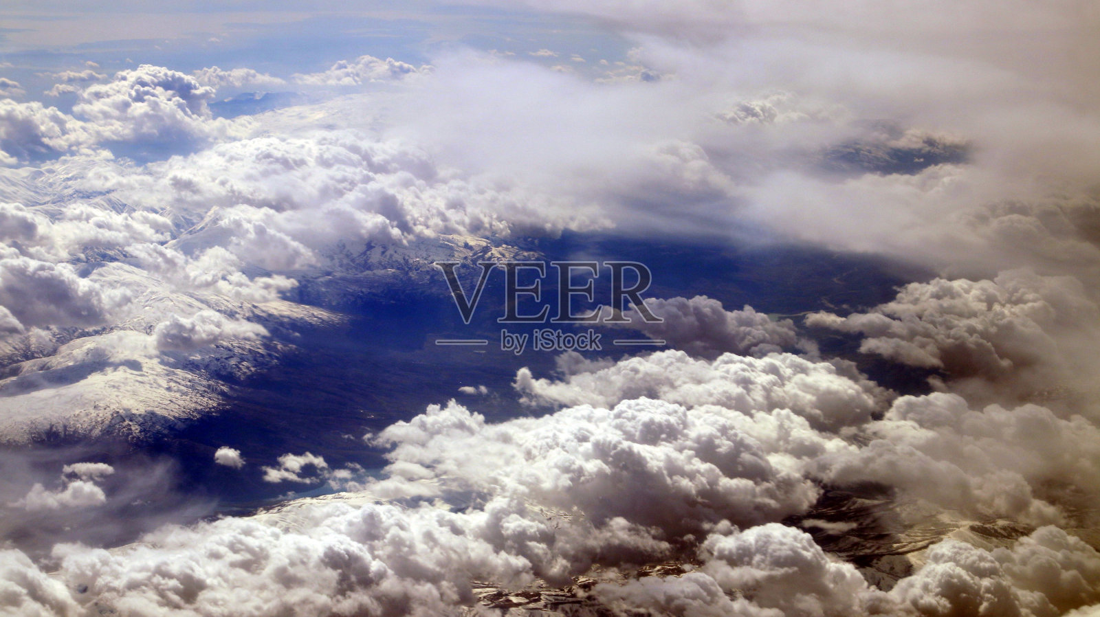 从飞机窗口看,云,山,天空和海洋是蓝色的照片摄影图片