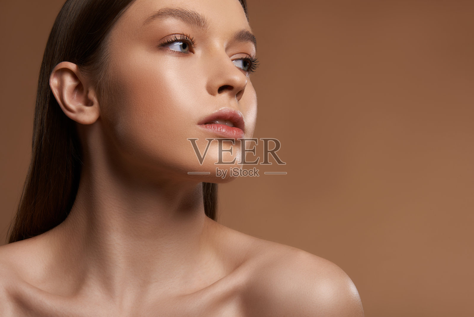 美丽的女士与自然的化妆摆姿势在浅棕色的背景照片摄影图片