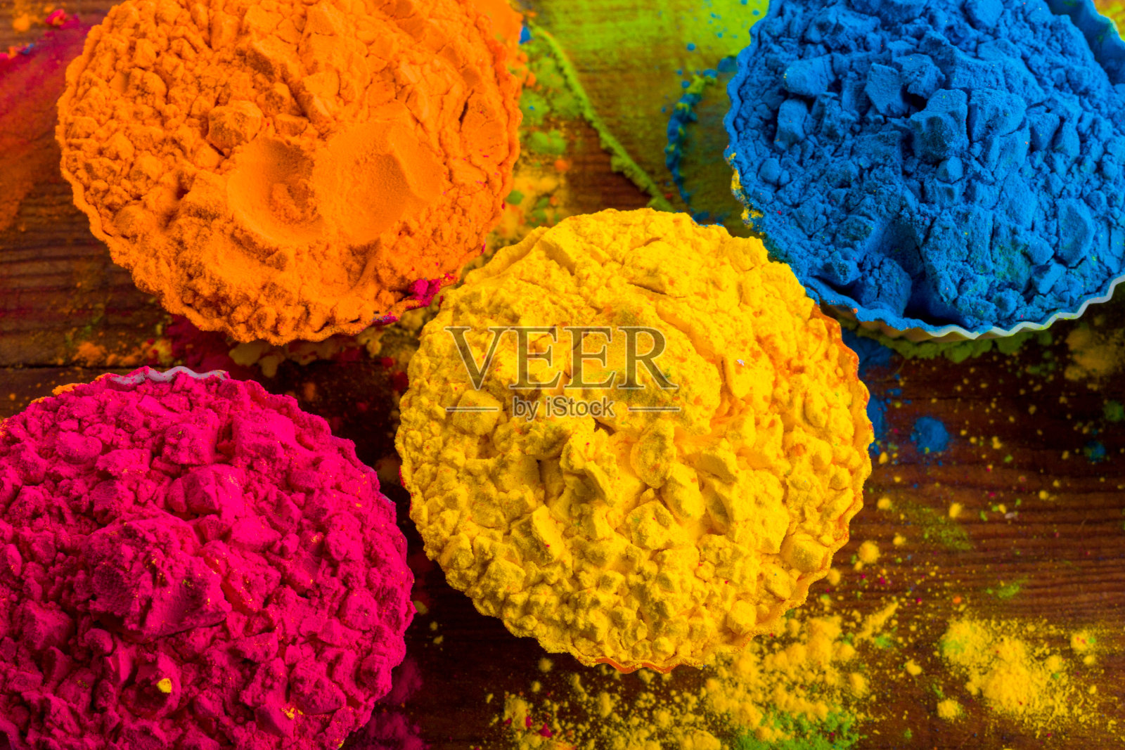 胡里节颜色粉。有机的红色碗为胡里节,印度传统节日。蓝色,粉色,品红,橙色,黄色胡里干油漆木桌背景照片摄影图片