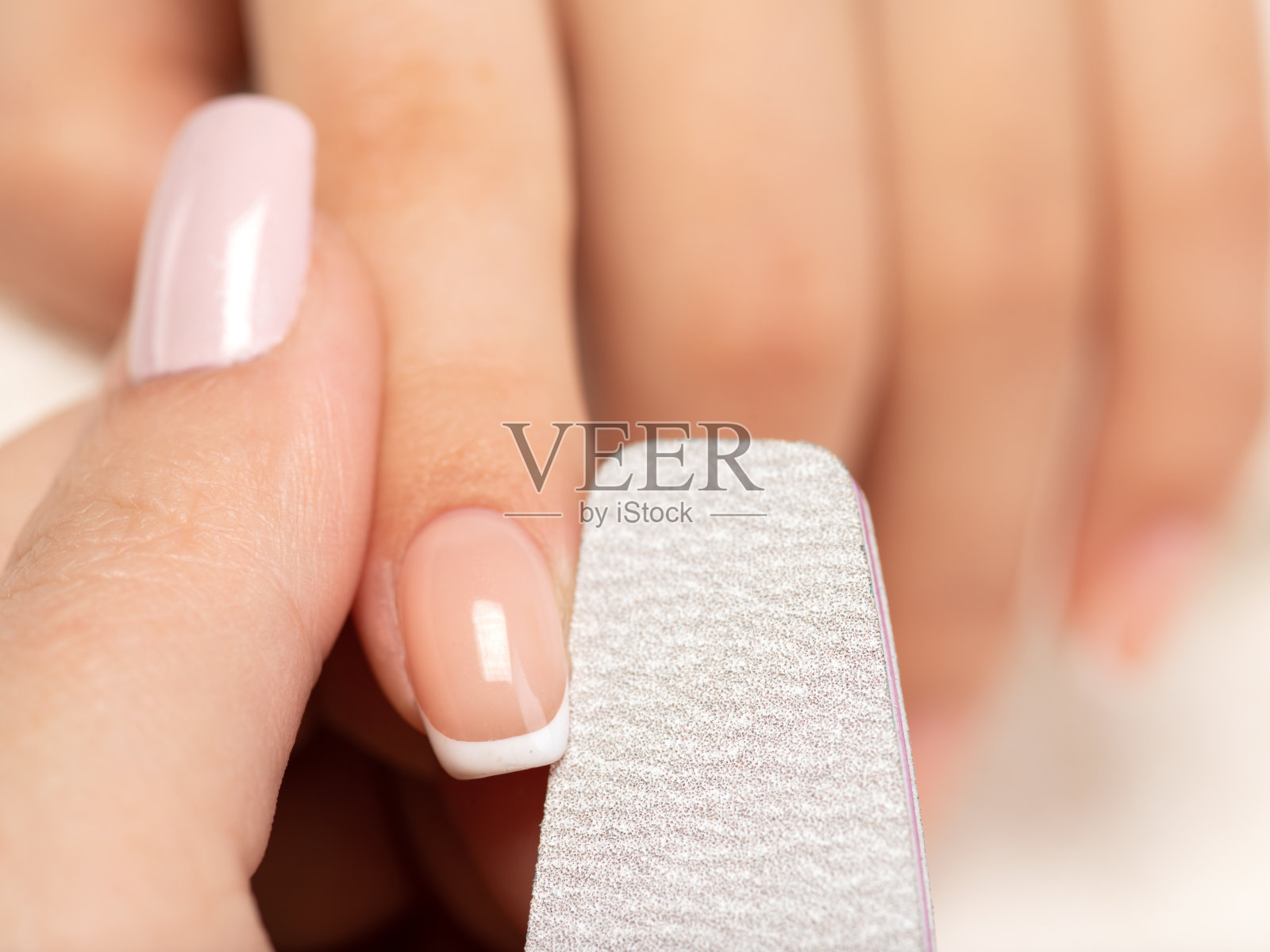 女人得到美甲程序在水疗沙龙。美丽的女性的手。照片摄影图片