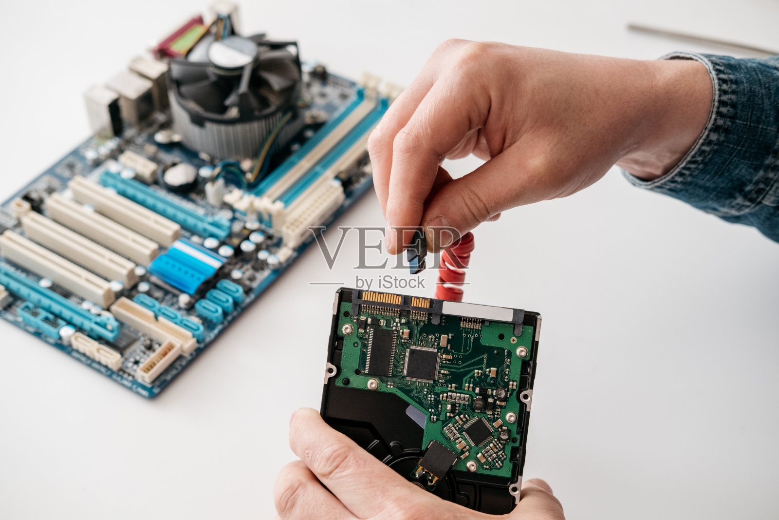 技术员将SATA (Serial AT Attachment, Serial ATA)电源线插入硬盘驱动器设备照片摄影图片