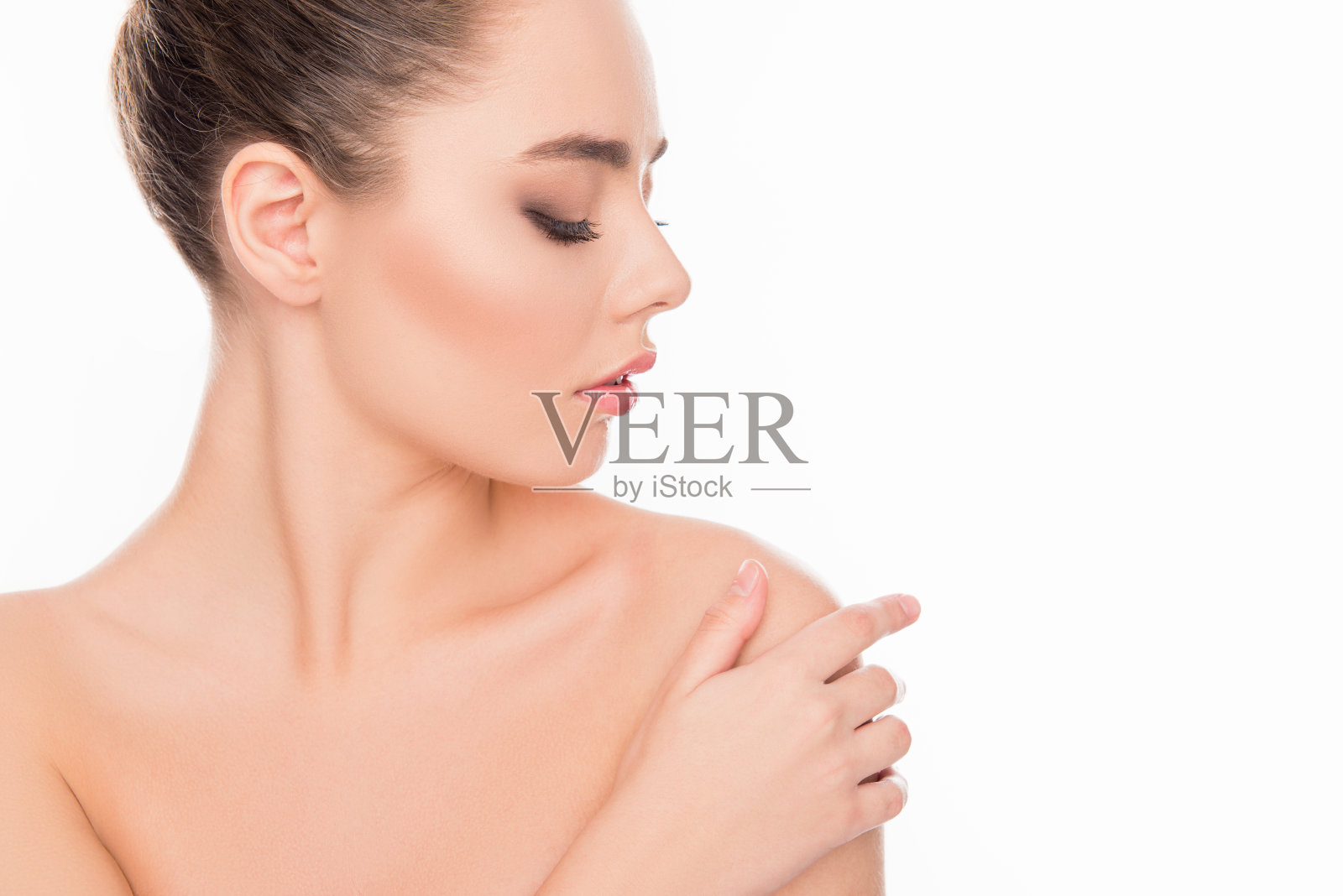 在白色的背景上,有思想的温柔漂亮的女人触摸肩膀的肖像照片摄影图片