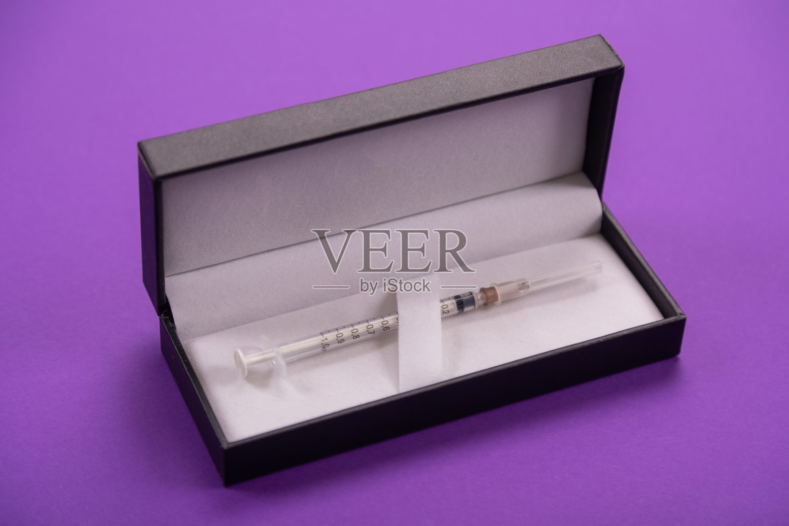 白色注射器在一个黑色的封面孤立的背景照片摄影图片