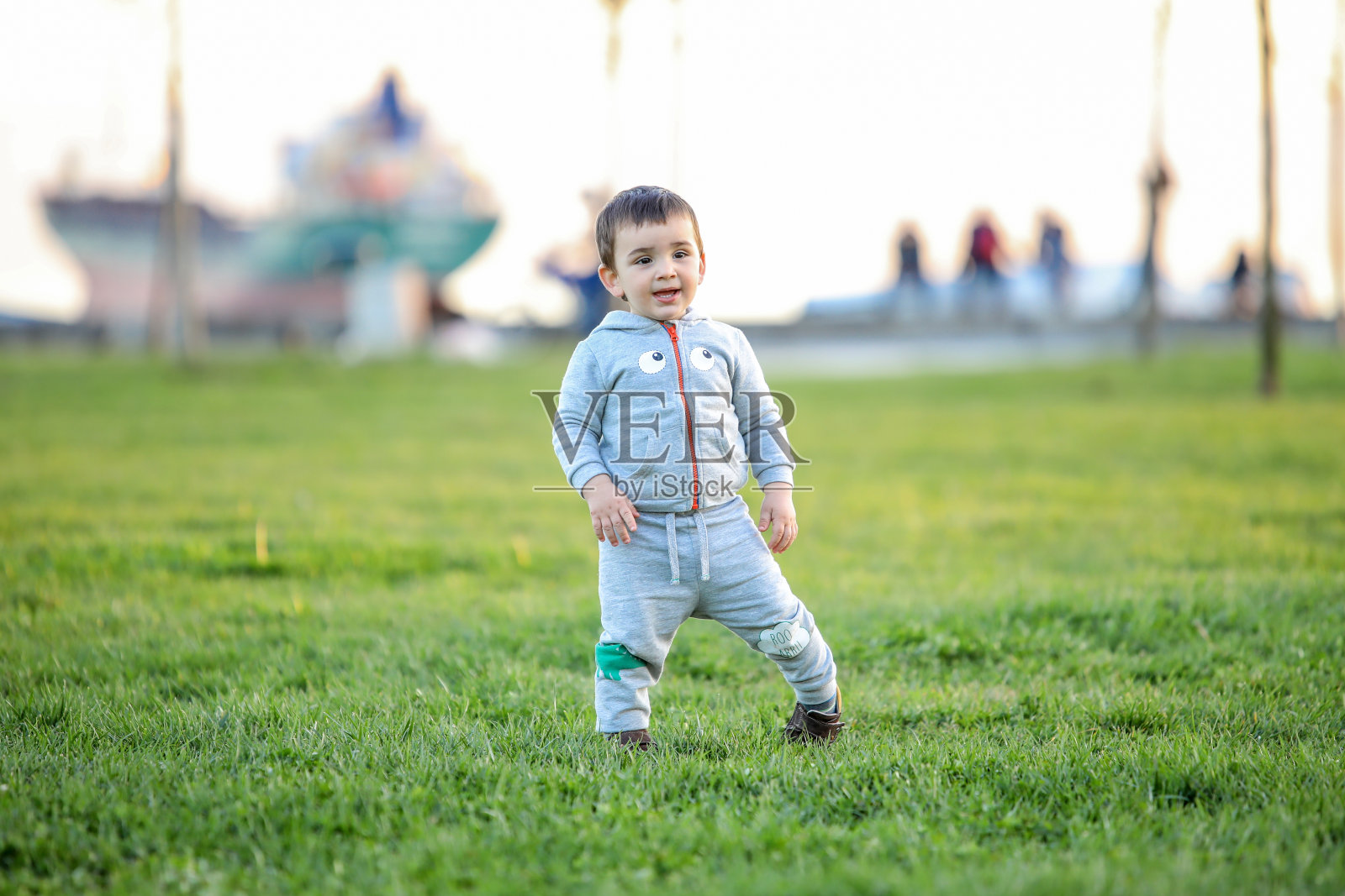 婴儿的第一步。独立的第一步。在公园里跑步的小孩。照片摄影图片
