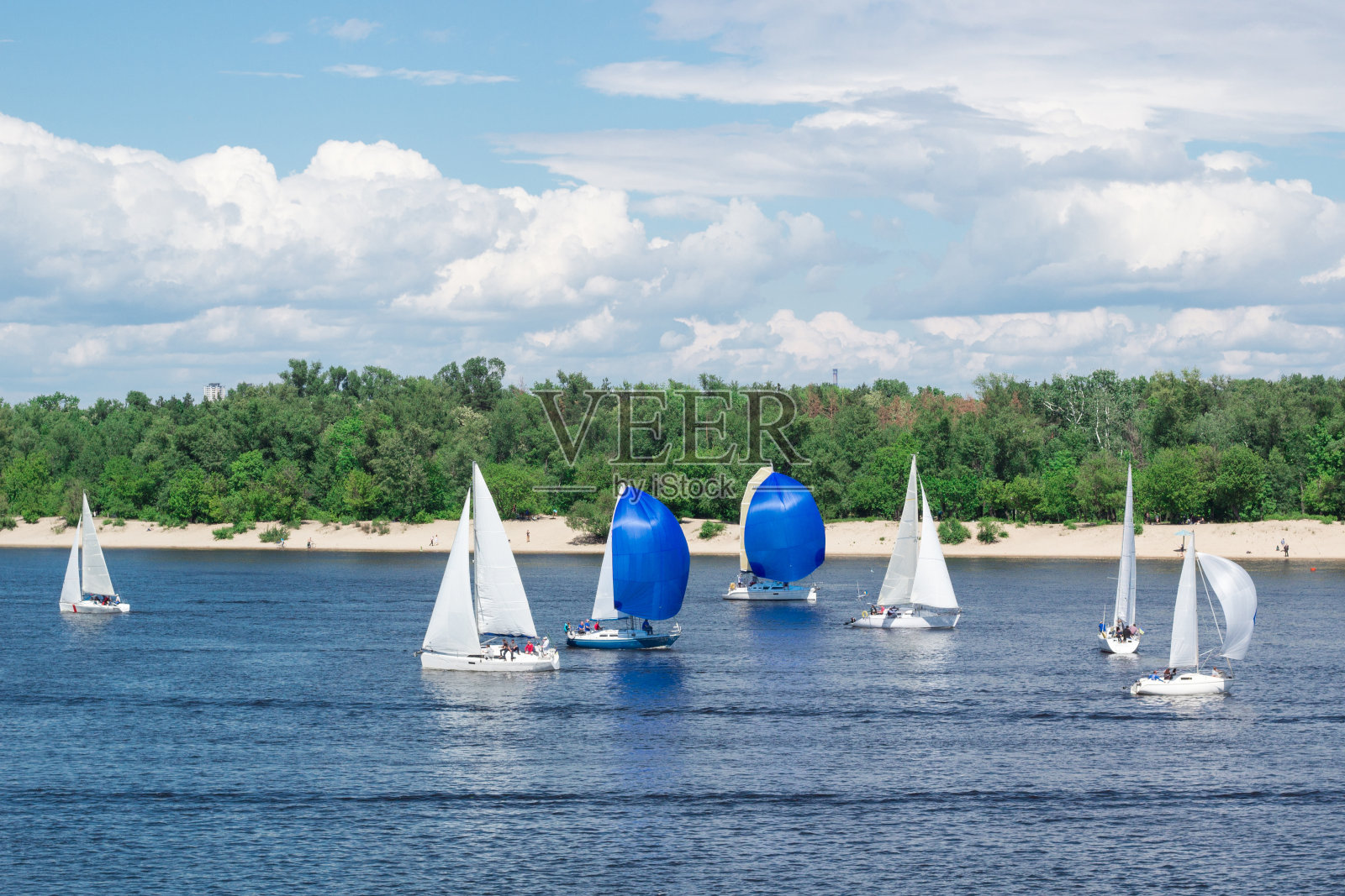 赛艇比赛在湖上的河上帆船的船与白帆和gennakers,反映天空的云在水中照片摄影图片