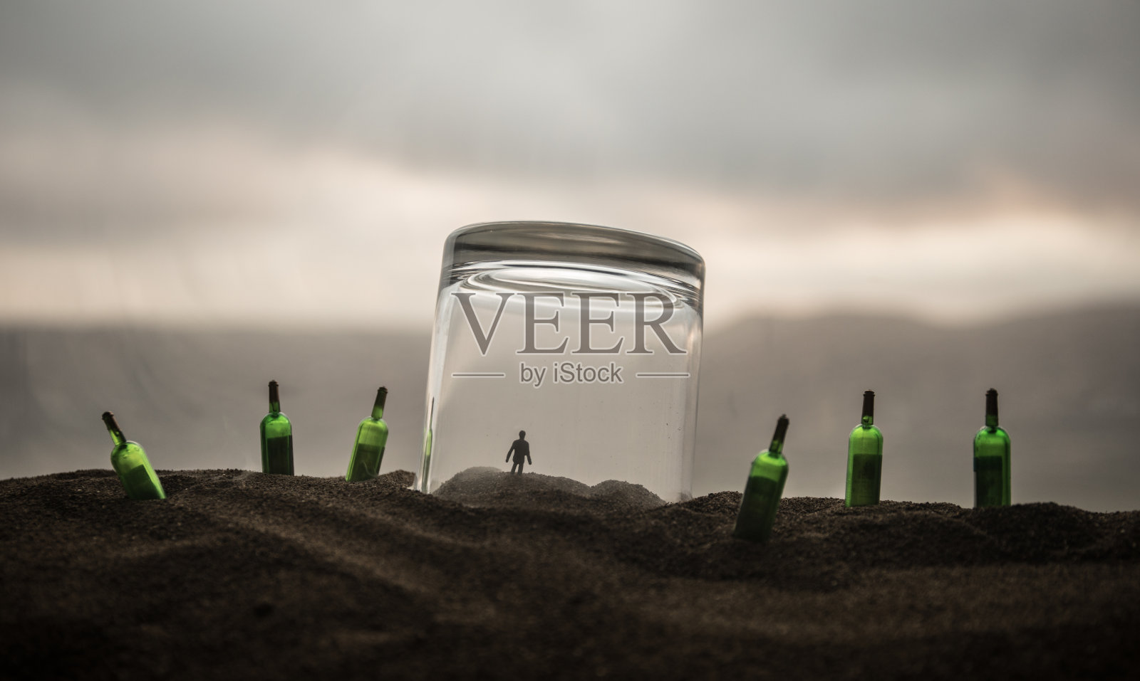 用来逮捕罪犯的铁手铐,木头上的一杯伏特加。背景。酒后犯罪。照片摄影图片