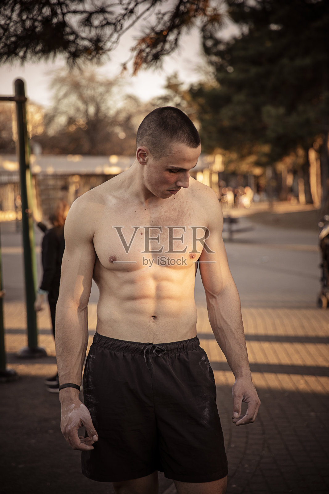 年轻的运动员在努力锻炼后站起来展示他的肌肉照片摄影图片