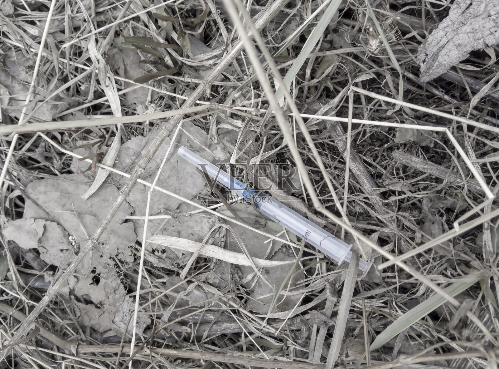 地上放着一个用过的注射器。照片摄影图片