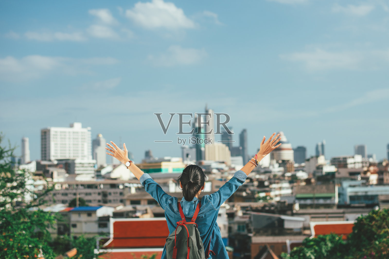 快乐的女人旅行者举起双手在城市场景背景与复制空间-感觉良好-放松和自由的概念照片摄影图片