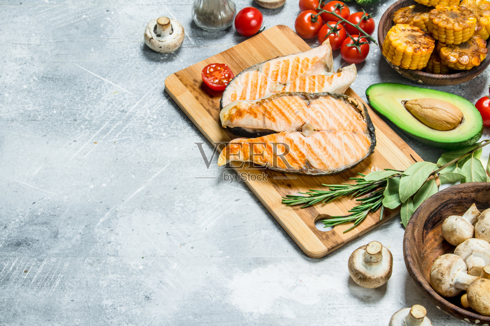 烤鲑鱼排和蔬菜放在木板上。照片摄影图片