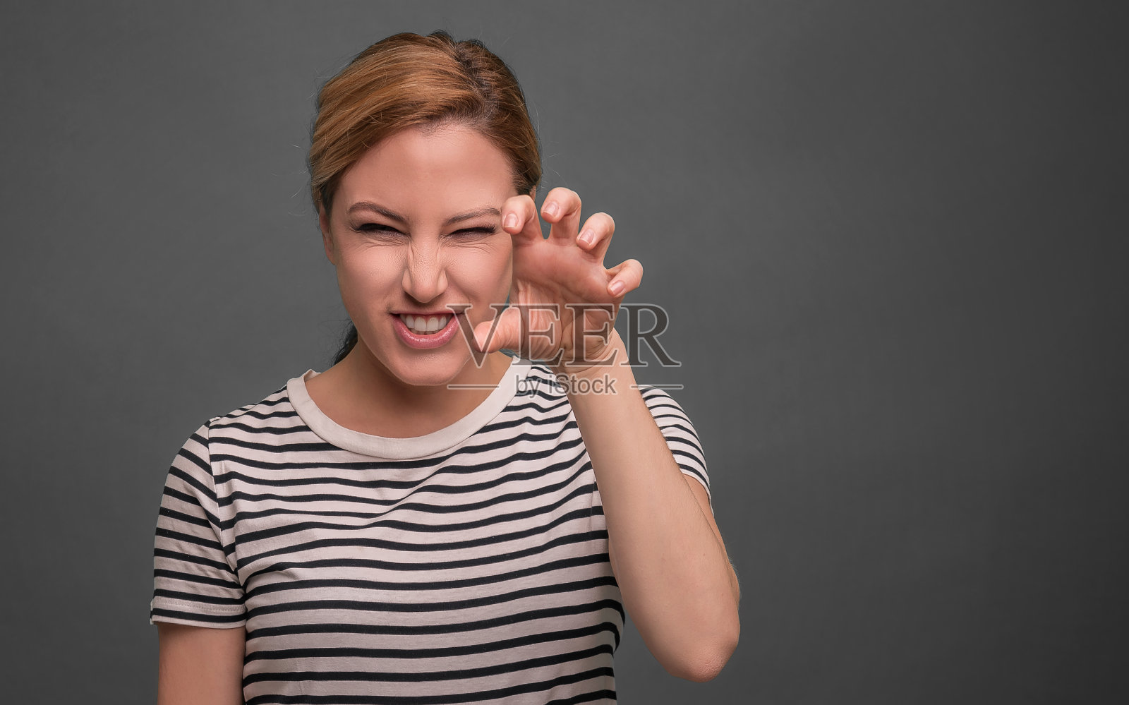 美丽的年轻女子显示爪子。照片摄影图片