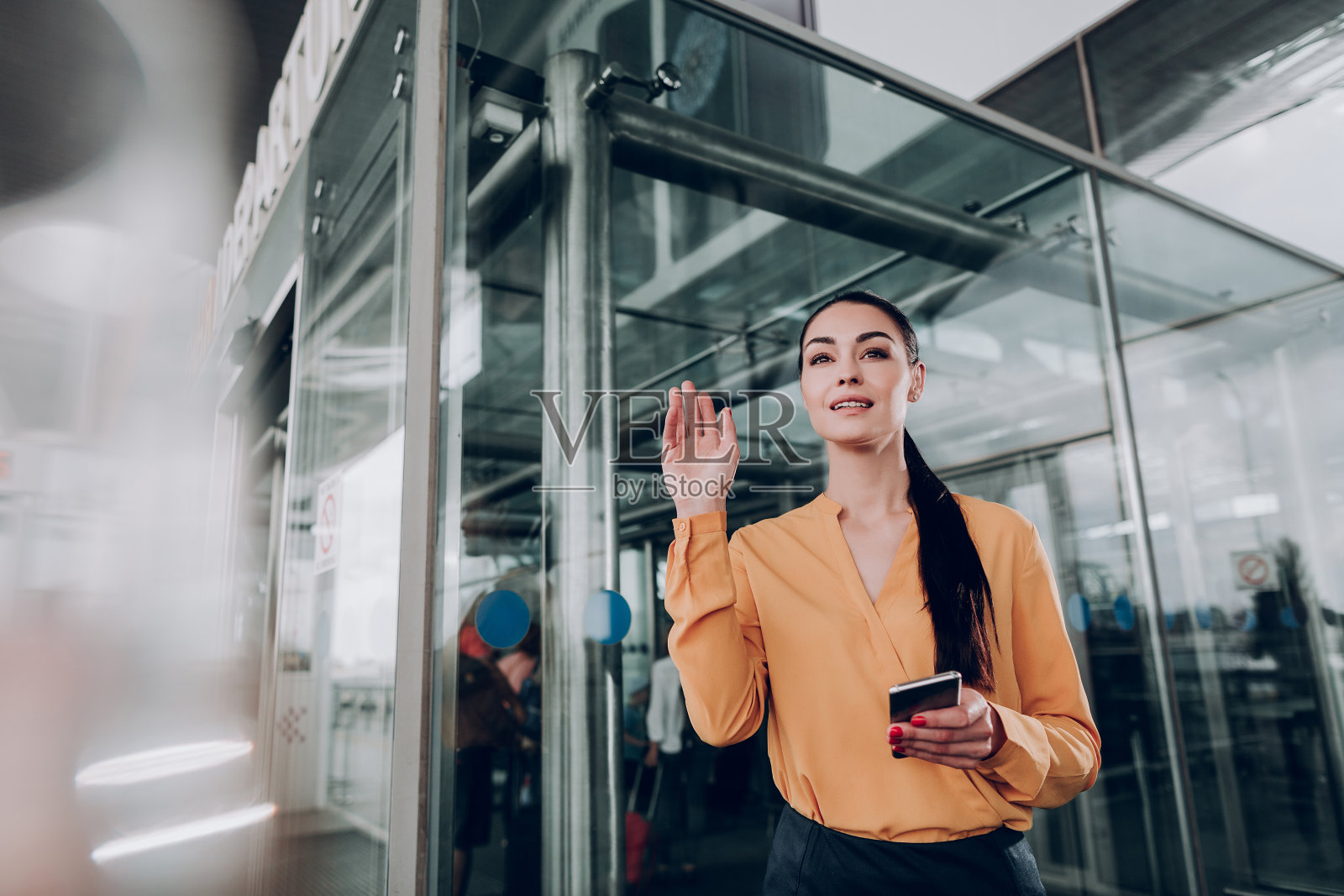 一个漂亮女人在车站附近打出租车照片摄影图片