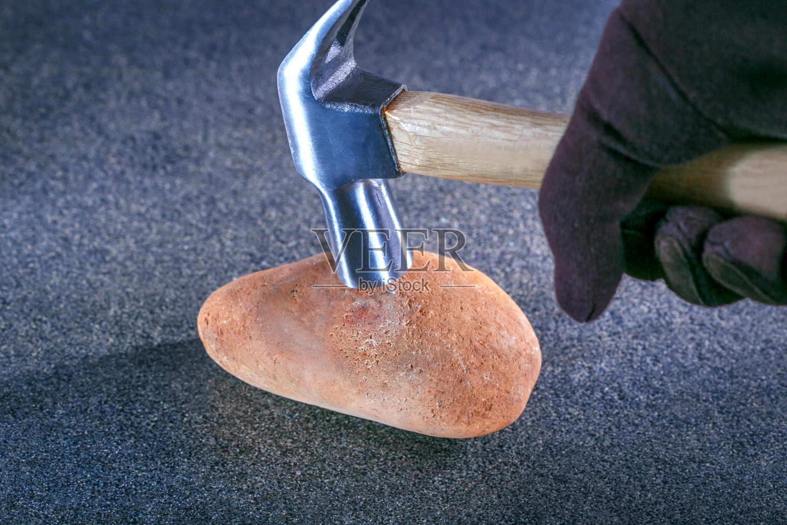 锤子敲击石头象征着稳定性测试。安全的概念照片摄影图片