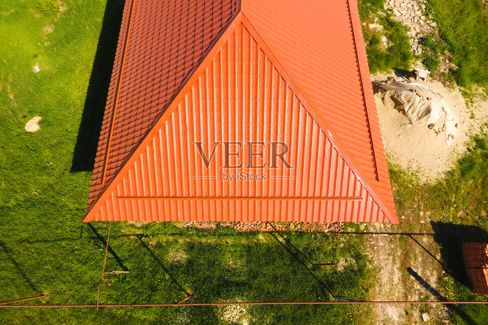 橙色金属屋顶的房子,俯视图。屋顶上涂有波纹的金属型材。照片摄影图片