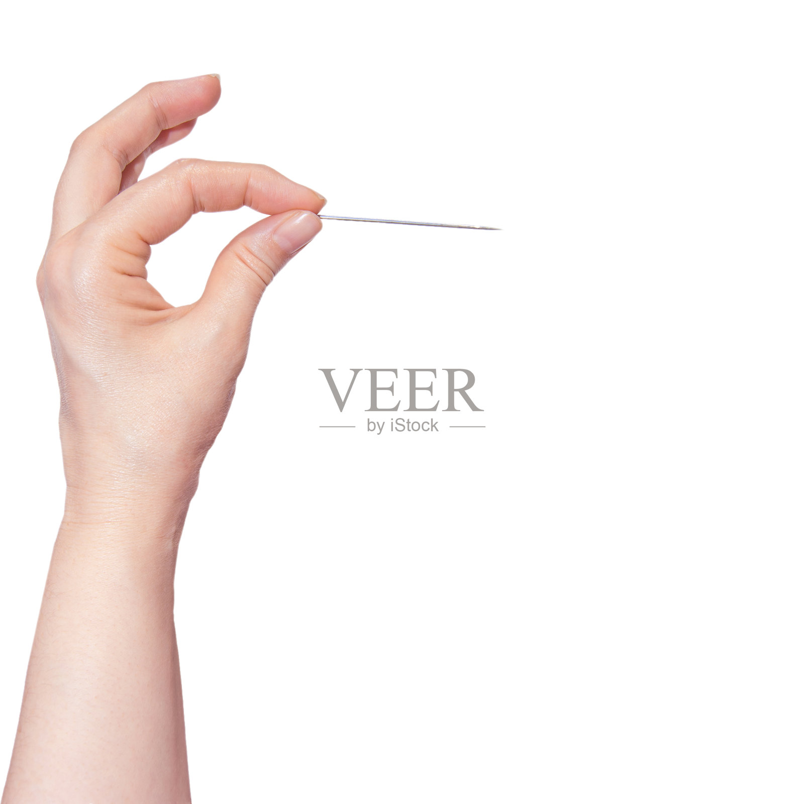 在白色的背景上,女人的手拿着一根针。照片摄影图片