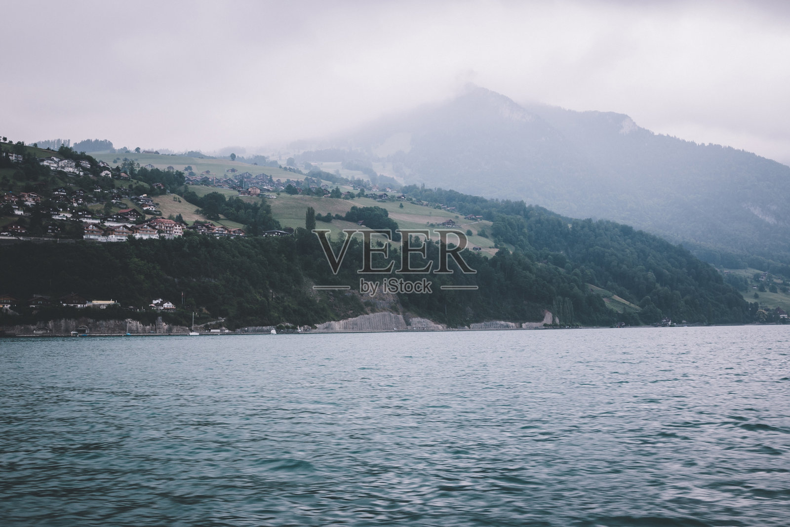 从瑞士施皮兹市的船上俯瞰图恩湖和群山照片摄影图片