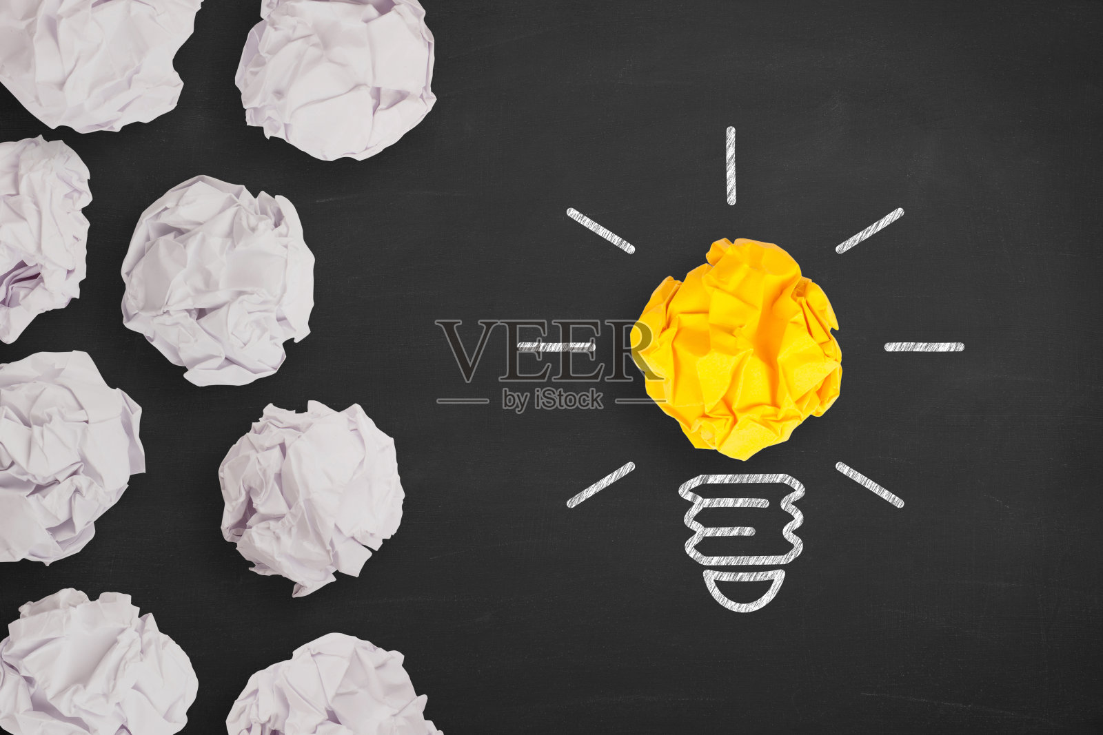 创意概念灯泡在黑板上皱巴巴的纸照片摄影图片