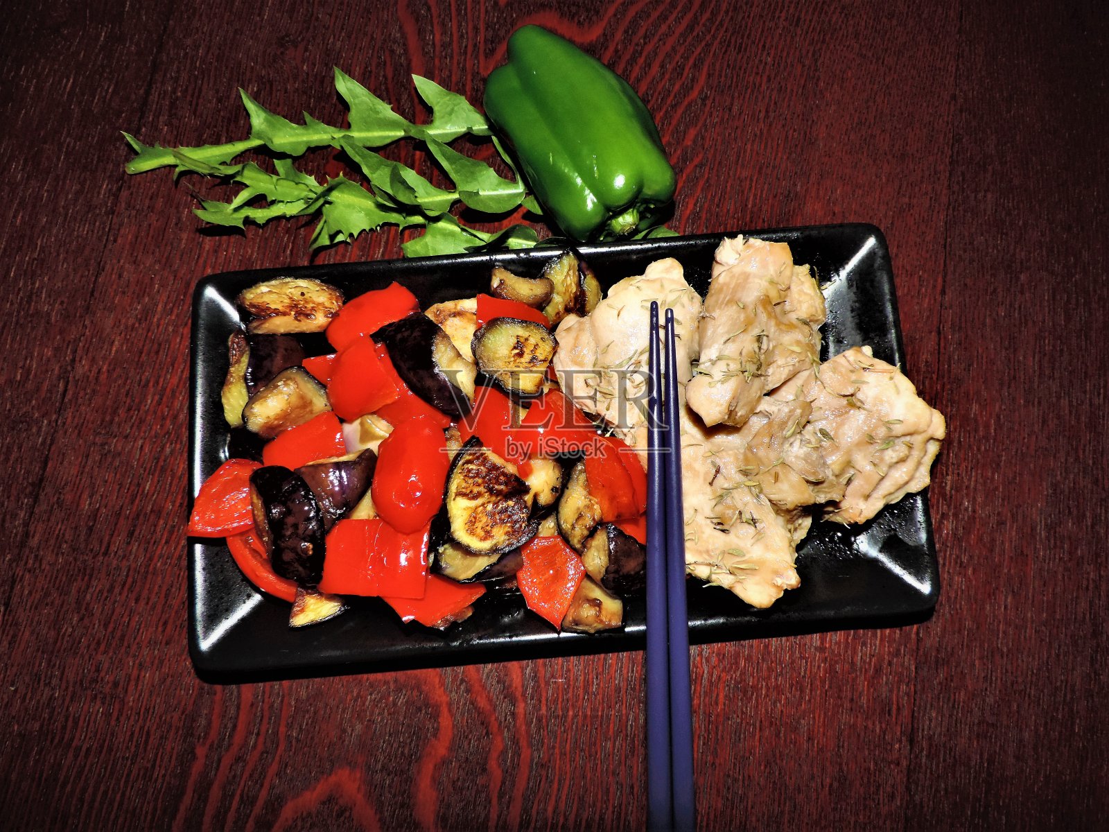 黑暗的美食。烤茄子,红辣椒和鸡肉照片摄影图片