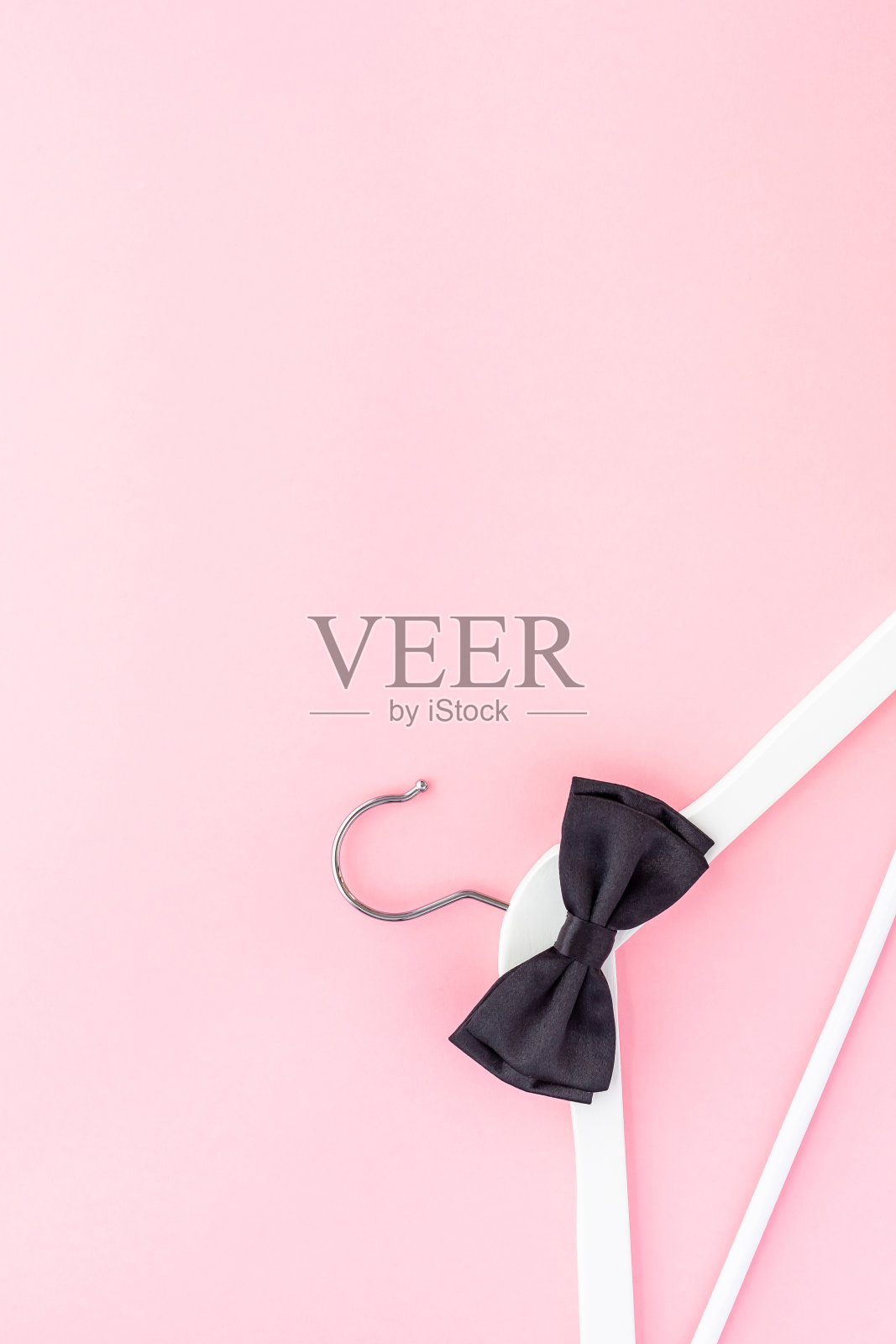 淡粉色背景上的白色衣架照片摄影图片