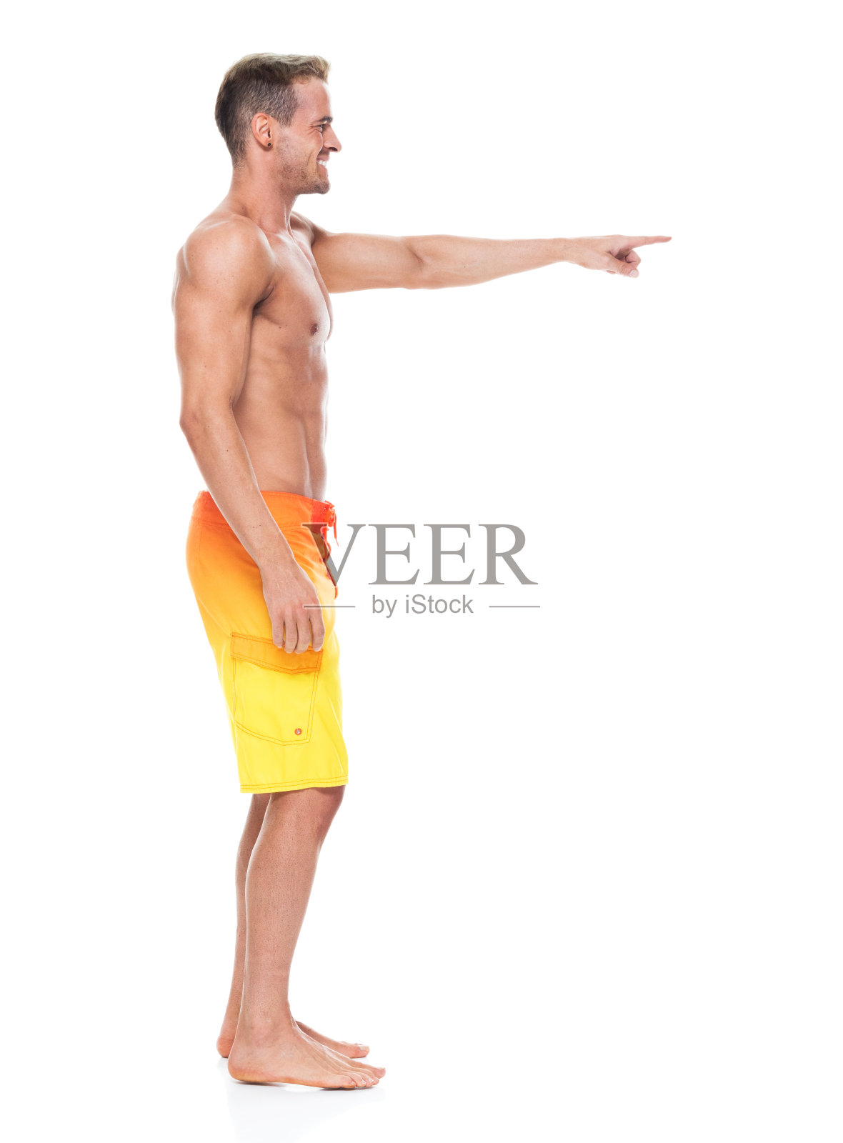 英俊的男子赤膊和穿板短裤指向照片摄影图片