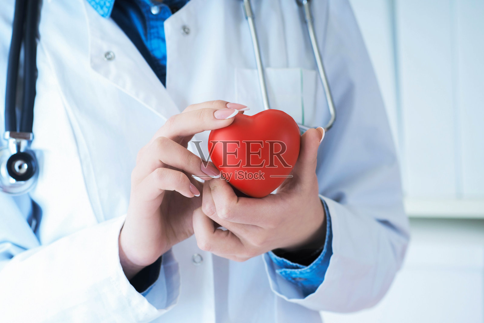 女医医生手里拿着红色的玩具心特写。心疗生教育理念照片摄影图片