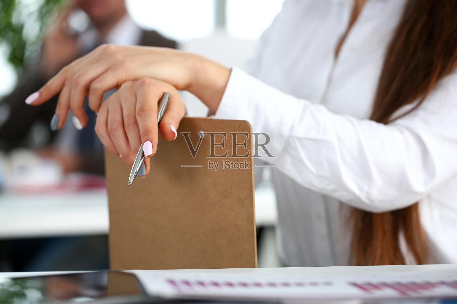 女性在西装的手臂拿着银笔和本子照片摄影图片