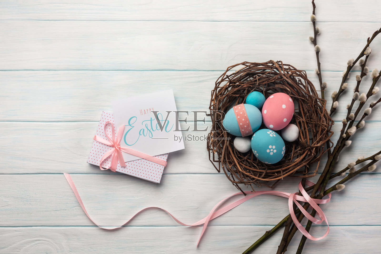 蓝色和粉红色的蛋在巢和猫咪柳树。复活节贺卡。顶视图与空间为您的问候照片摄影图片