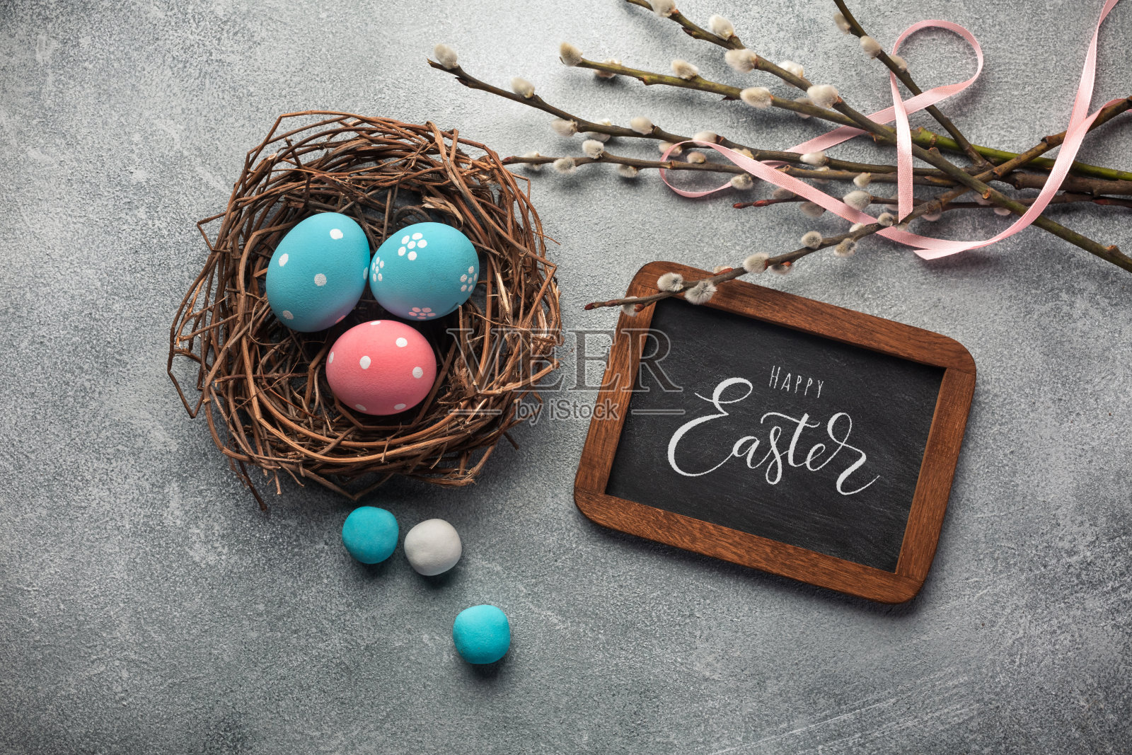 蓝色和粉红色的蛋在巢和猫咪柳树。复活节贺卡。顶视图与空间为您的问候照片摄影图片