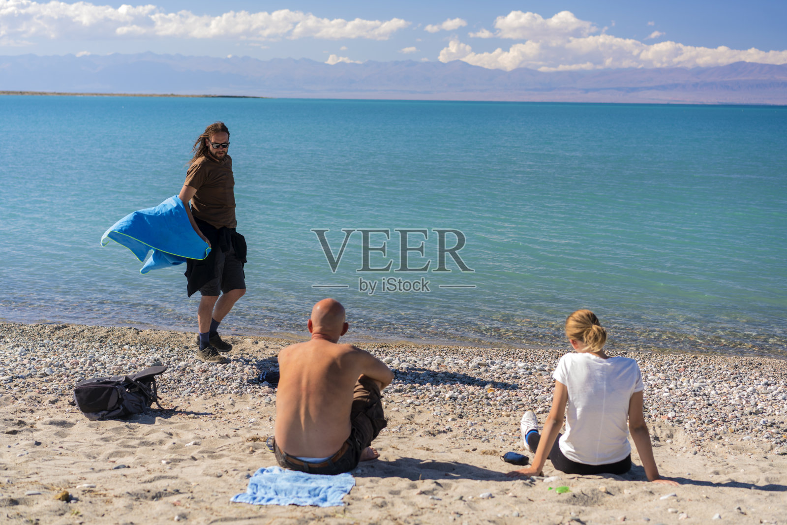 游客在伊塞克库尔湖沐浴和晒毛巾后,吉尔吉斯斯坦照片摄影图片