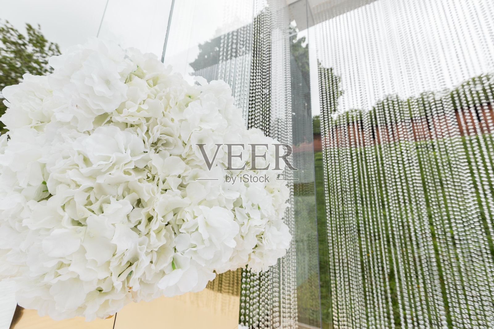 水晶装饰的婚礼,豪华的装饰。美丽的拱门装饰链与透明的珠子在绿色草坪的背景照片摄影图片