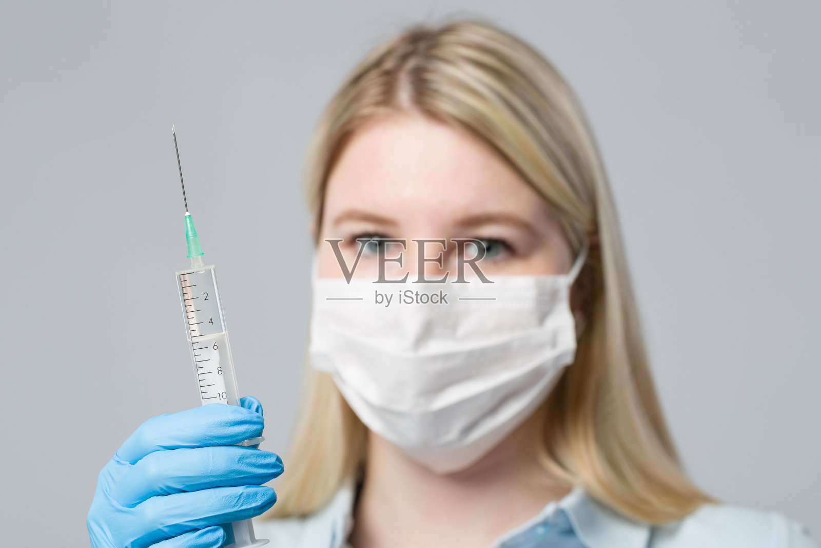 戴医用手套和医用口罩的护士正拿着注射器照片摄影图片