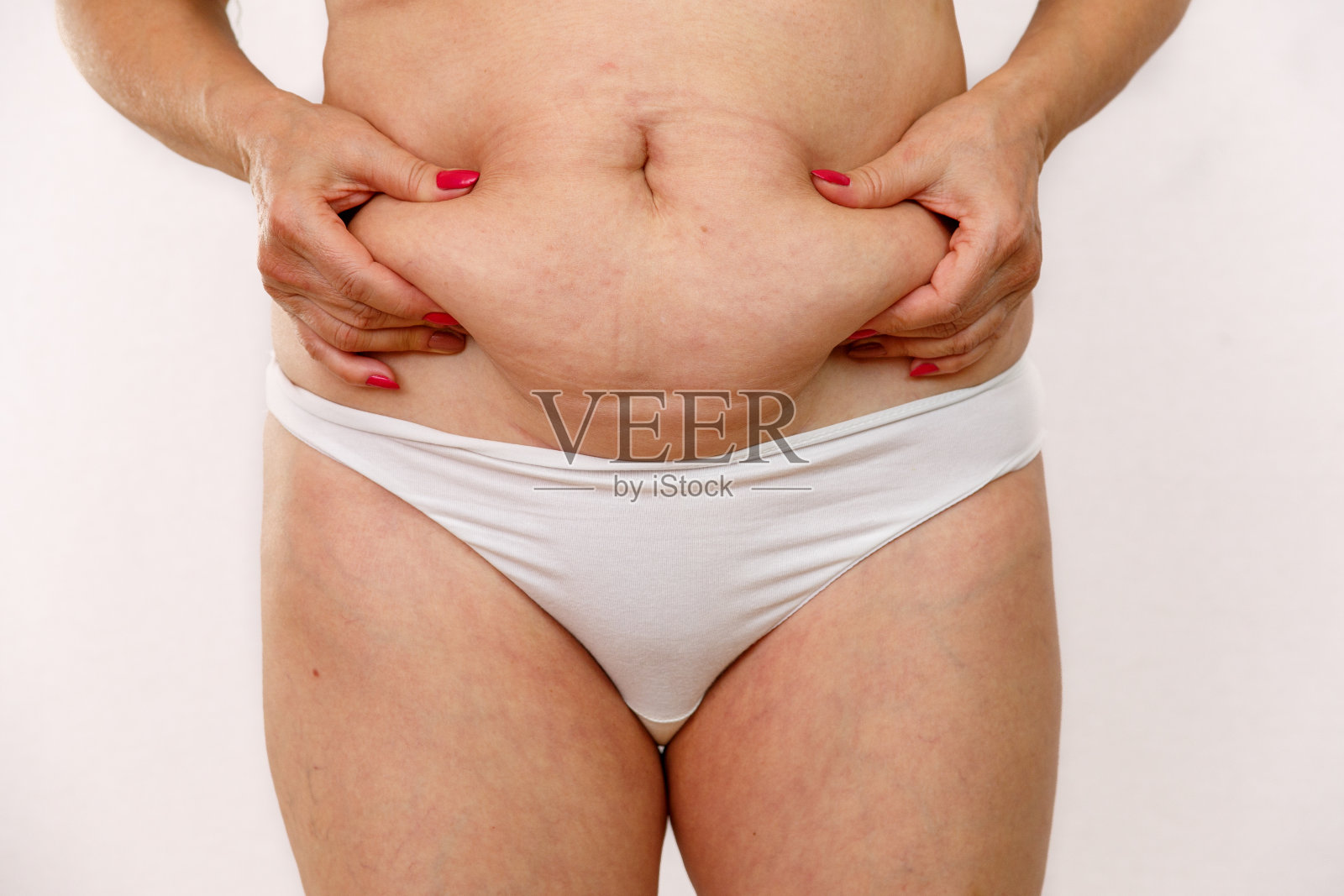 上了年纪的女人露出大肚子照片摄影图片