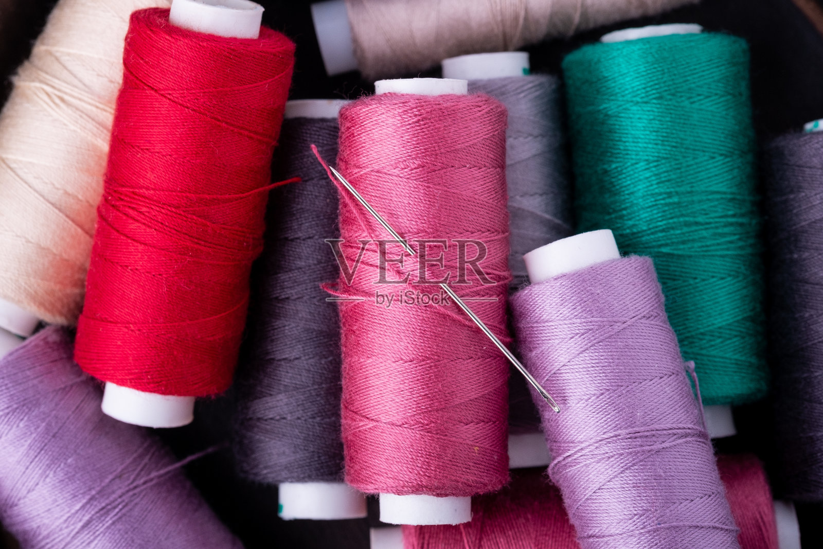 俯视图的近景分散彩色棉线线圈与针照片摄影图片