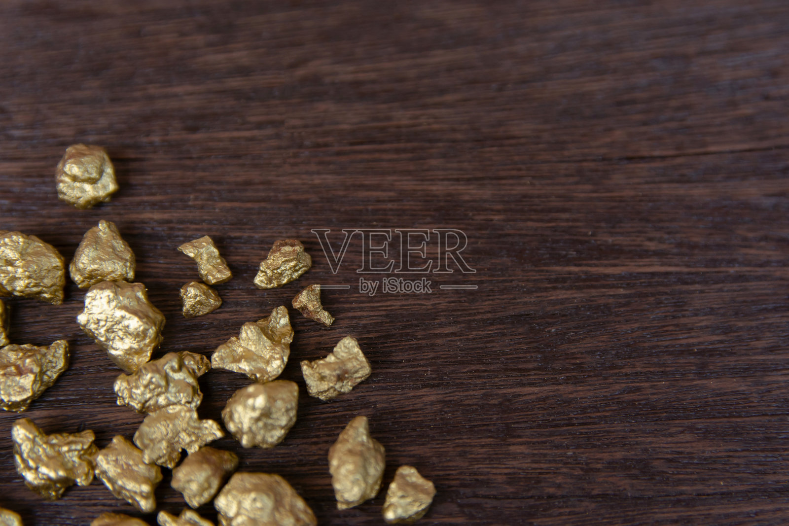 在黑木背景上堆砌的金块照片摄影图片