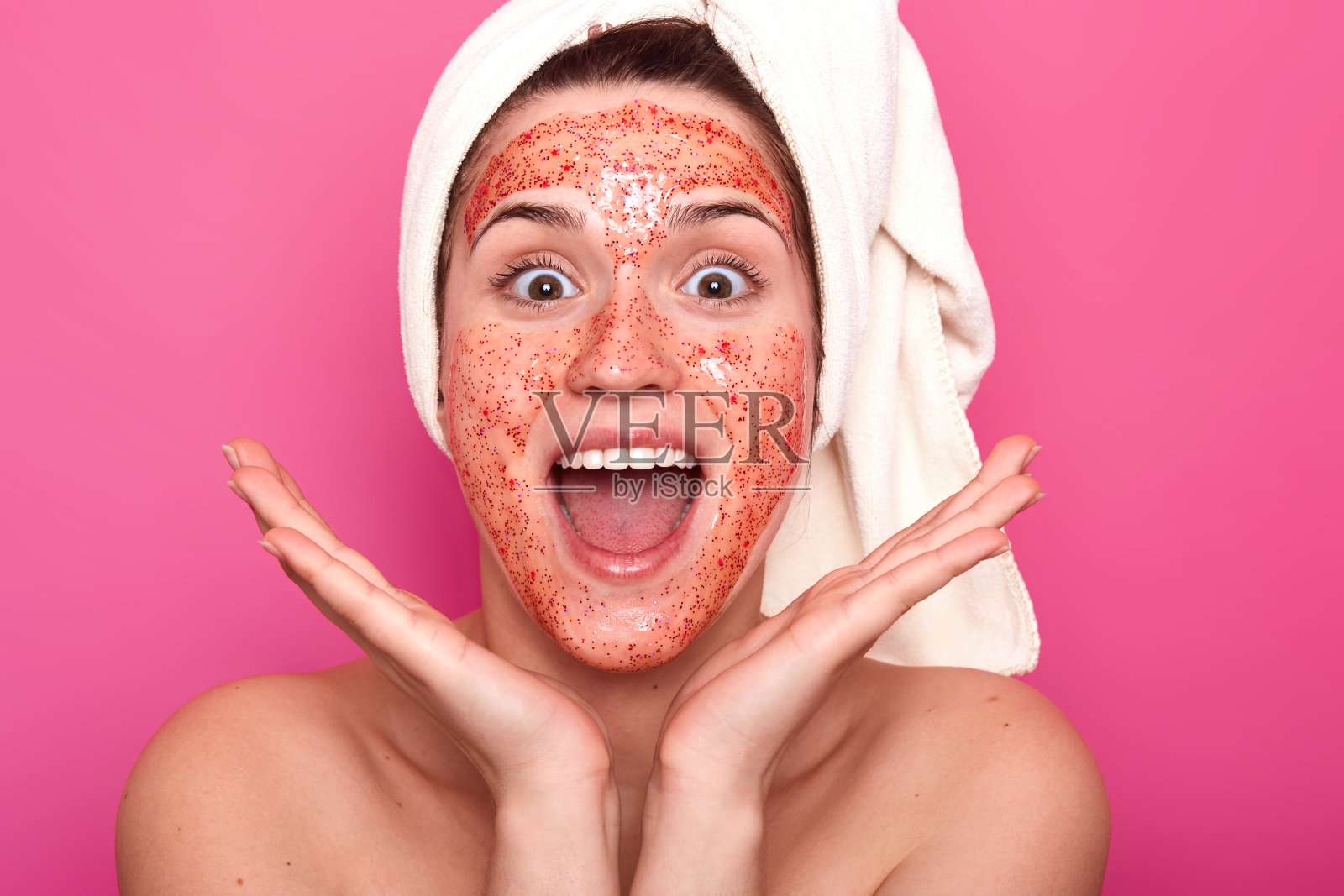 有趣的情绪化的年轻女子叫满意,把她的手靠近头部,张开的嘴和眼睛大,有白色的毛巾覆盖头发,看起来很高兴。美容护肤理念。照片摄影图片