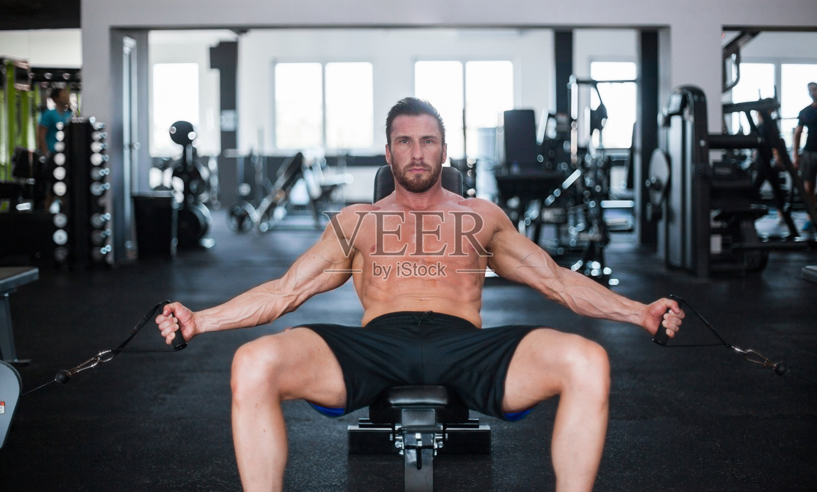 肌肉男在拉线机上锻炼胸肌照片摄影图片