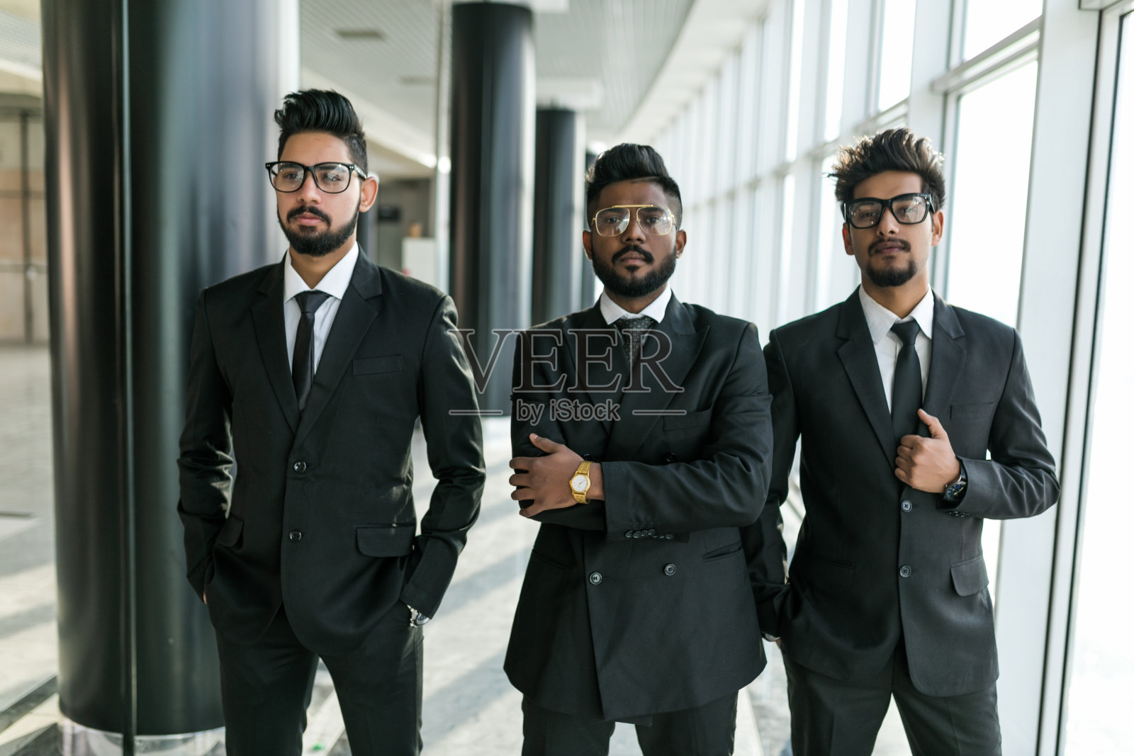 三个亚洲商人双手交叉站在会议室靠窗的地方照片摄影图片