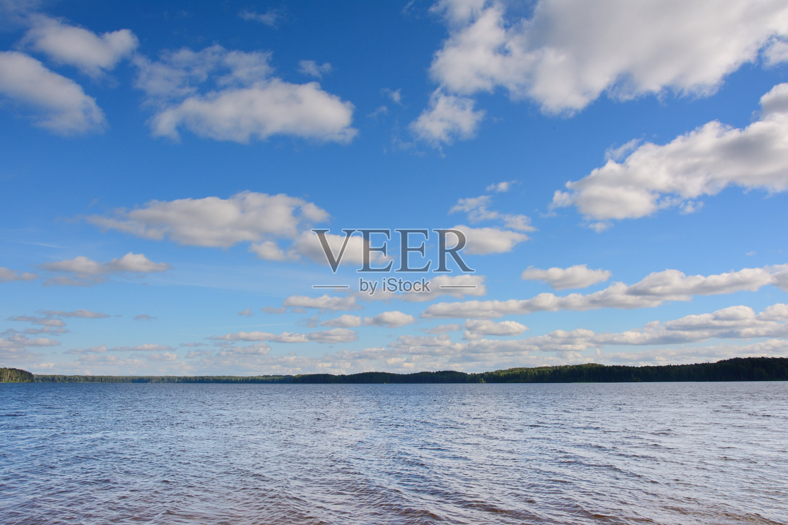 在白云和蓝天的映衬下,海岸线的轮廓很细照片摄影图片