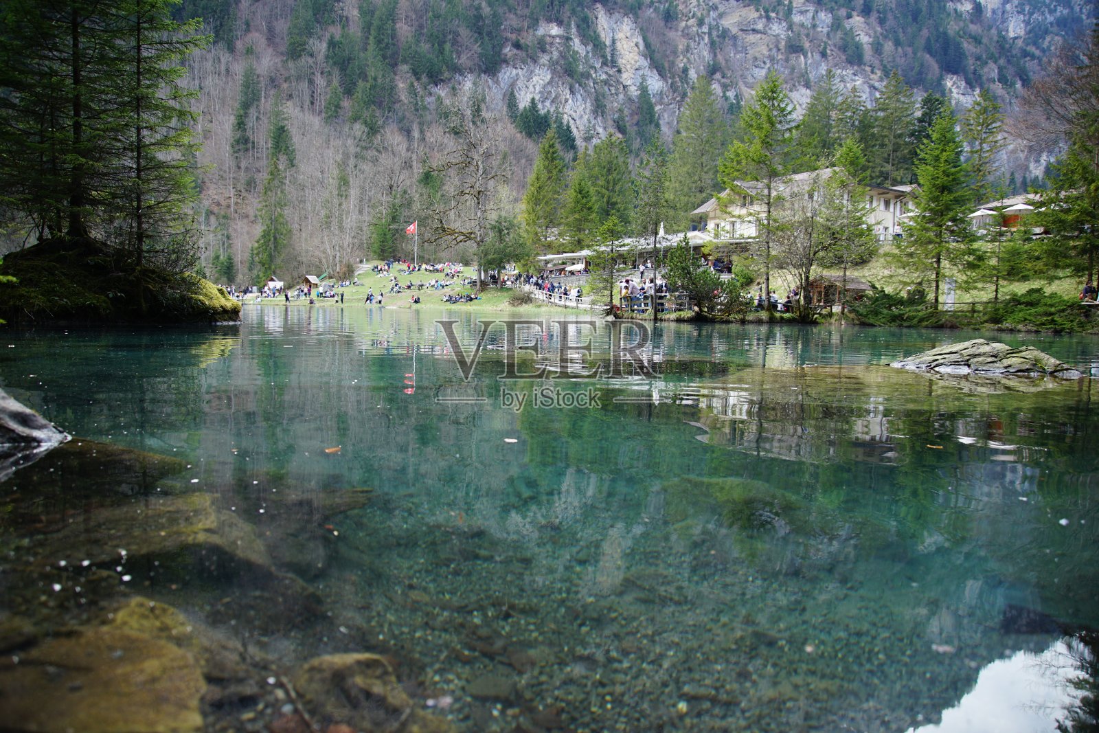 在阳光明媚的日子里,有蓝色清澈的水的小湖照片摄影图片