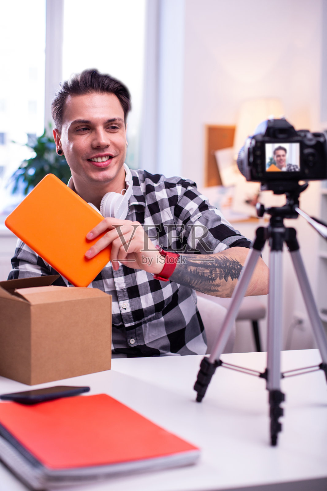 微笑短发男子拆封新的创新橙色平板电脑照片摄影图片