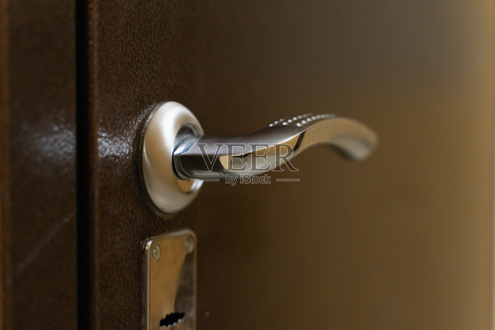 镀铬门把手与锁在金属前门照片摄影图片