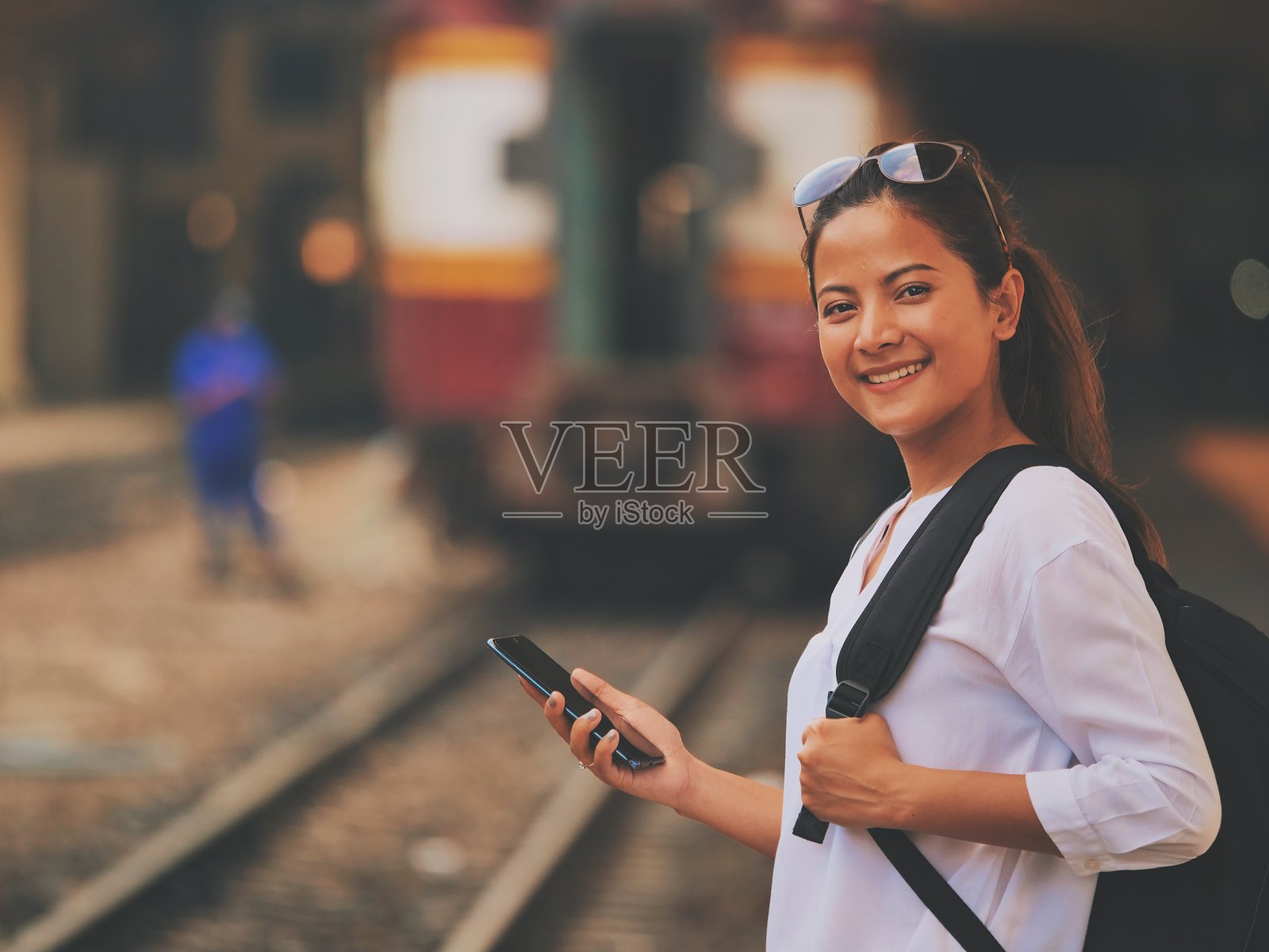 亚洲妇女在城市旅行带着手机照片摄影图片