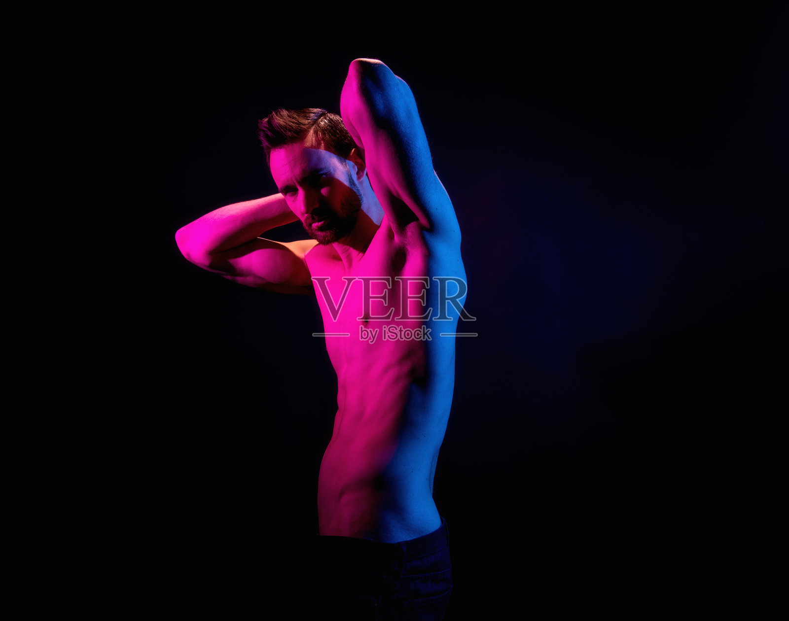 英俊的男子在黑色背景与红色和蓝色照明照片摄影图片