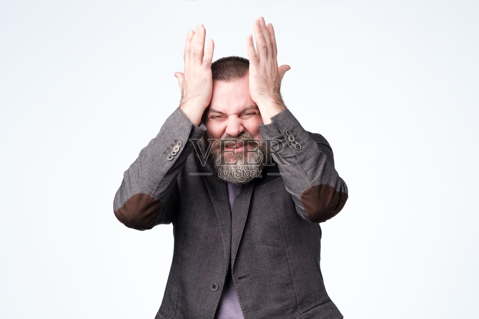 双手放在太阳穴上,难以思考的男人照片摄影图片