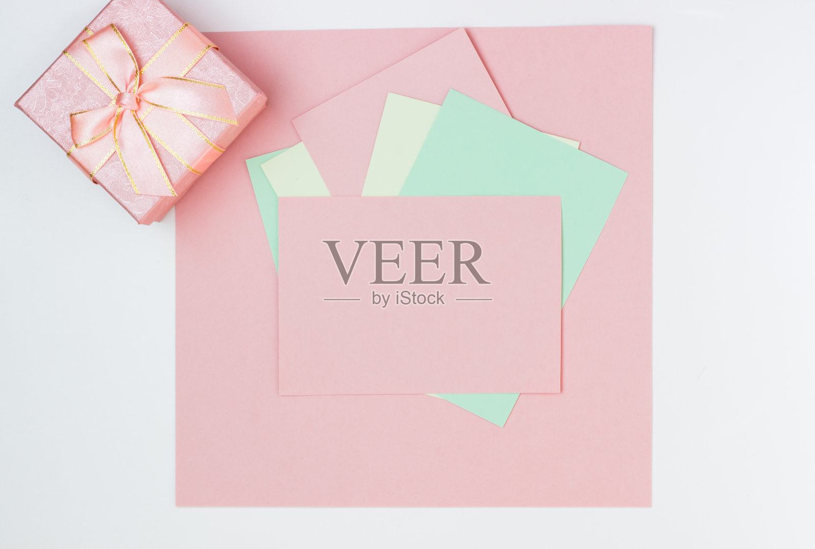 粉红色的空卡片,书写纸。布局添加标签与礼盒。俯视图,平放,复制空间照片摄影图片