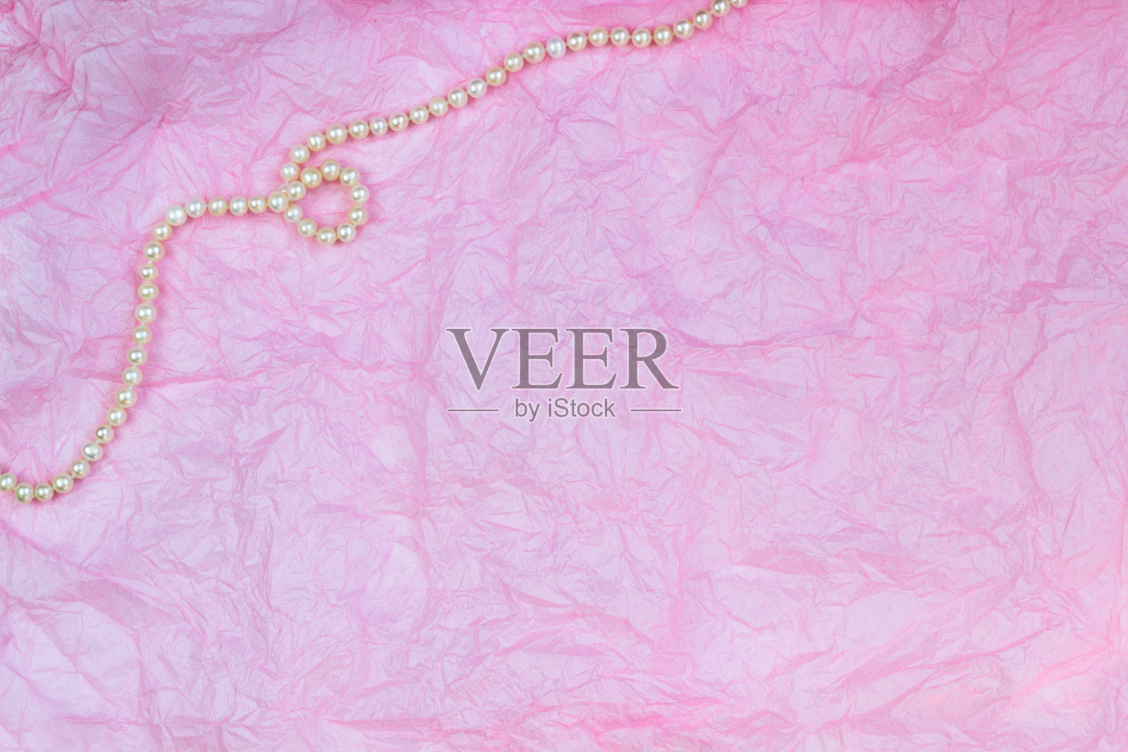 珍珠项链上的粉色皱纸纹理背景照片摄影图片