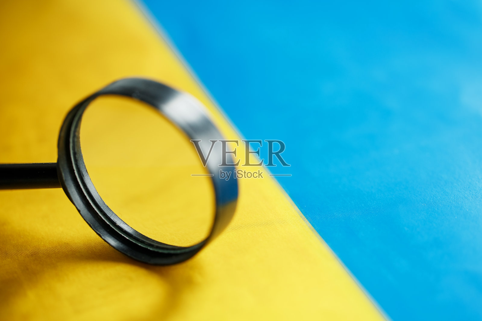 用放大镜看乌克兰国旗。全面监视乌克兰。隐藏的威胁和对国家的控制照片摄影图片