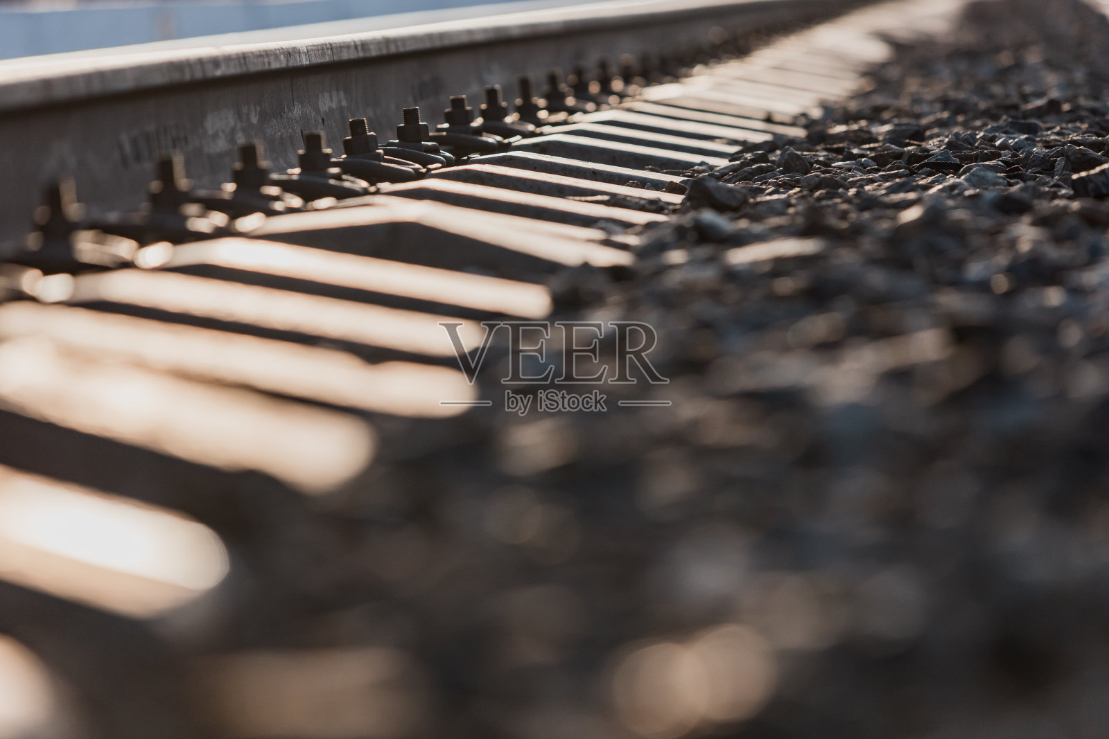 可以看到铁轨、混凝土枕木和碎石堆。铁轨。照片摄影图片