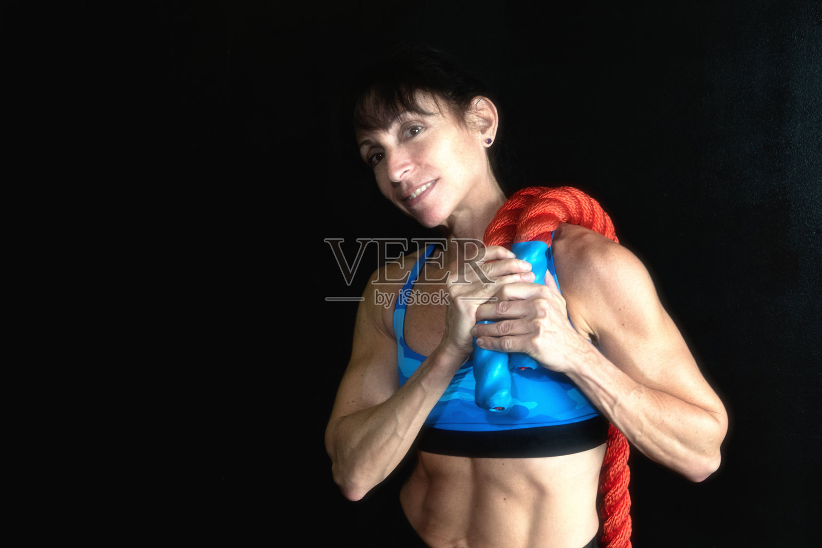 女性健美运动员与加重绳摆姿势照片摄影图片