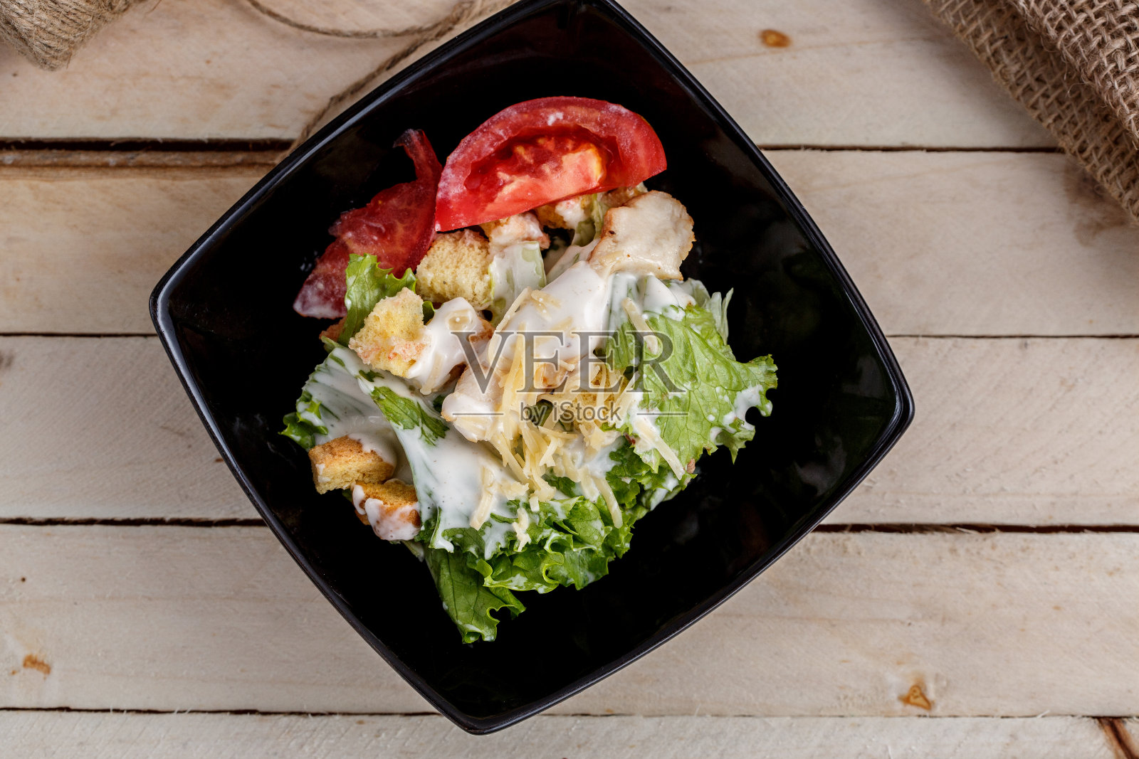 黑色盘子里的凯撒沙拉。从上往下看照片摄影图片